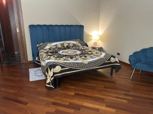 a bed in a room with a blue head board at B&B Piazza Duomo al 55 in Voghera