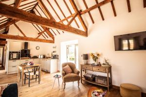 a living room with a table and a chair at Wyns Barn in Rhayader