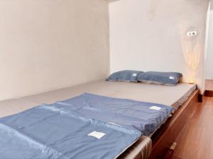 a bed in a room with blue sheets on it at Bin Homestay Hải Phòng in Hai Phong +1 photo
