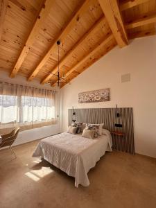 a bedroom with a large bed and a wooden ceiling at Casa rural Los Acebos in La Cuesta