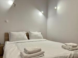a bedroom with a bed with towels on it at The Central Stay in Cluj-Napoca +5 photos