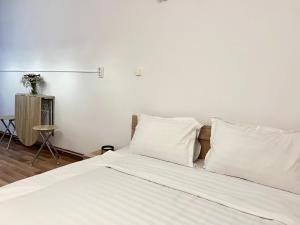 a bed with white sheets and pillows in a room at The Central Stay in Cluj-Napoca