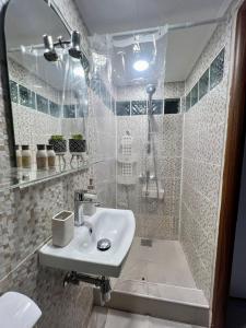 a white bathroom with a sink and a shower at The Central Stay in Cluj-Napoca