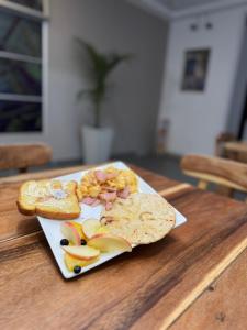 a plate of food with bread and fruit on a table at Hotel San Miguel src in Santa Rosa de Cabal