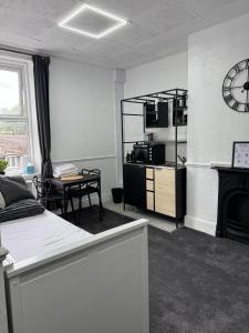 a room with a bed and a table and a clock at The Wickham Arms Hotel in Cleckheaton +55 photos