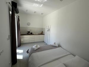 Habitación blanca con 2 camas y lavamanos en Sudio by the Sea, en Milna