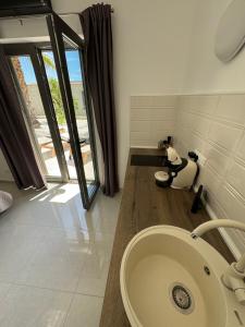 Un baño con lavabo y una gran ventana. en Sudio by the Sea, en Milna