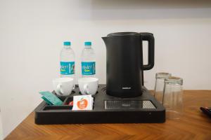 a coffee maker on a table with bottles of water at Hotel Super Stay in Ujjain