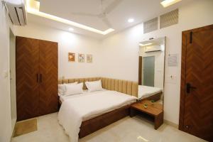 a small bedroom with a bed and a mirror at Hotel Super Stay in Ujjain