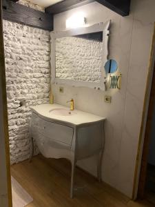 a bathroom with a sink and a mirror at En Camargue, Gite Cosy climatisé jacuzzi en sus, proche lac et mer in Vauvert