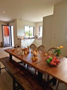 - une table en bois avec un bol de fruits dans l'établissement Maison proche de la mer, à Pénestin