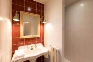 un bagno con lavandino e specchio di Les vignes blanches a Beaune Altre 21 foto