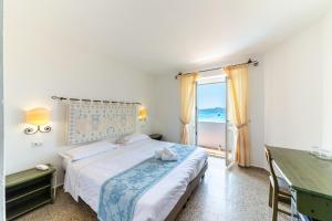 a bedroom with a bed and a view of the ocean at Hotel Castello in Golfo Aranci