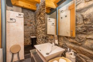 a bathroom with a sink and a stone wall at Casa Guillem 2 in Tavascan +23 photos