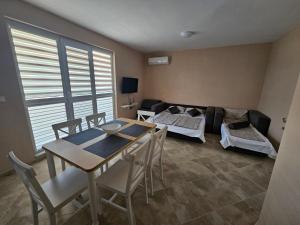 a living room with a table and a couch at Апартаменти Кастро2-Castro Apartments2 in Tsarevo
