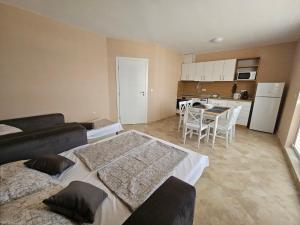 a living room with a couch and a table and a kitchen at Апартаменти Кастро2-Castro Apartments2 in Tsarevo +47 photos