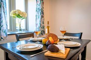 einen Tisch mit Tellern und Gläsern Wein und Essen in der Unterkunft Residence Cottage in Beaumaris