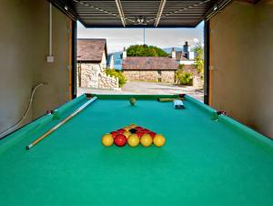 einen Billardtisch mit Bällen in einem Zimmer mit Fenster in der Unterkunft Residence Cottage in Beaumaris