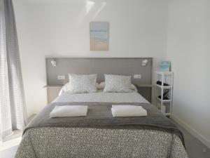 a bedroom with a large bed with two pillows at Pes Na Area Fisterra 01 in San Martín de Arriba