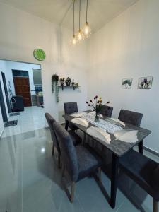 a dining room with a wooden table and chairs at Homestay CikguMa 4 - Wi-Fi in Kota Bharu