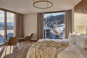 a bedroom with a large bed with a large window at Hotel GRACE LA MARGNA ST MORITZ in St. Moritz
