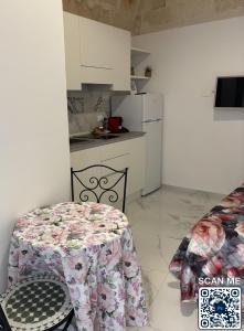 a kitchen with a table and a chair with a tablecloth at Affittacamere Marì in Polignano a Mare +7 photos