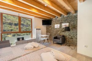 a bedroom with a bed and a stone wall at Casa Guillem 3 in Tavascan