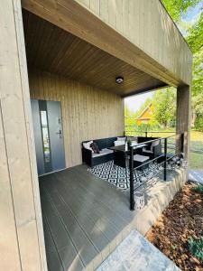 a covered deck with a couch and a table at Lakeview Okuninka in Okuninka +3 photos