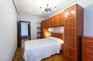 a bedroom with a bed and a large wooden cabinet at Apartamento La Vega de Santiago 1 in Posada de Llanes