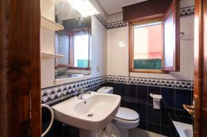 a bathroom with a white sink and a toilet at Apartamento La Vega de Santiago 1 in Posada de Llanes +18 photos