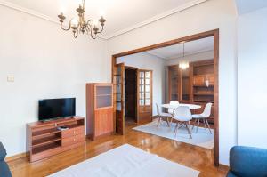 a living room with a television and a table at Apartamento La Vega de Santiago 1 in Posada de Llanes