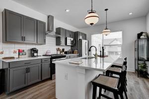 a kitchen with gray cabinets and a white counter top at Specious Luxury wRooftop 1 mi DT Indy Sleeps 6 in Indianapolis +93 photos