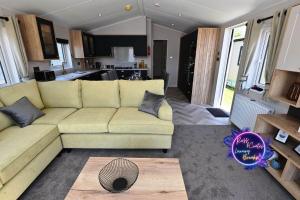a living room with a couch and a kitchen at Big Duffs Den in Tattershall