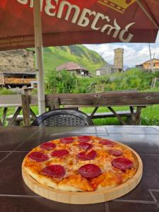 a pepperoni pizza sitting on top of a table at Chvibiani Guesthouse & Bar in Ushguli