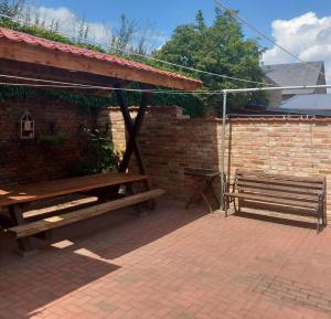 a patio with two wooden benches and a brick wall at Trebelsee 2 Monteur- und Ferienwohnung in Ketzin
