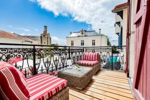 a balcony with two chairs and a table on a balcony at Hotel du Balcon in Capbreton