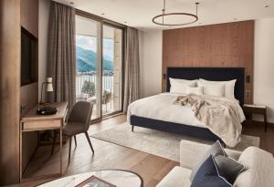 圣莫里茨Hotel GRACE LA MARGNA ST MORITZ的一间配有床、书桌和沙发的酒店房间