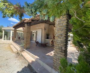 a house with a stone pillar and a patio at Villa les Faou-Anis in Le Castellet