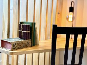 a pile of books sitting on a table next to a chair at Les Planches in Verdun-sur-Meuse