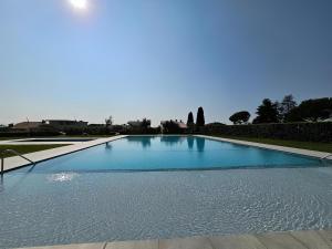una gran piscina con agua azul en Villa Sophora, en Moniga del Garda