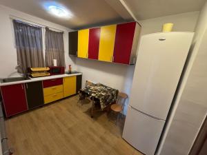 a small kitchen with a table and a refrigerator at Neptun Smart Flat in Neptun
