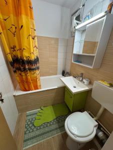a bathroom with a toilet and a sink and a tub at Neptun Smart Flat in Neptun