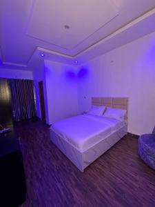 Un dormitorio con una gran cama blanca en una habitación morada. en The traffic light lagos, en Ikeja 13 fotos más