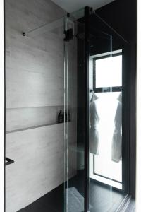 a shower with a glass door in a bathroom at Kauri Lodge -Luxury waterfront in Pouto +32 photos
