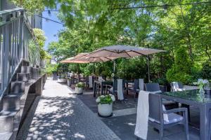 a patio with tables and chairs and an umbrella at Hotel Apis in Krakow