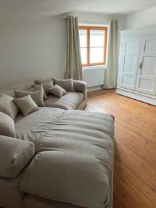 a couch sitting in a living room with a window at Inselperle Loft-Studio in Fehmarn