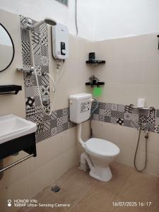 Un baño con inodoro, lavabo y ducha. en Laman Hanaz, en Pantai Cenang 14 fotos más