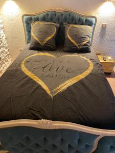 a bed with a heart with the words love arrival on it at En Camargue, Gite Cosy climatisé jacuzzi en sus, proche lac et mer in Vauvert