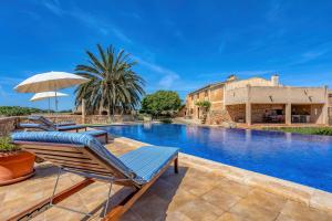 a pool with two lounge chairs and an umbrella at Na Corma Nova by dracmallorca in Calonge