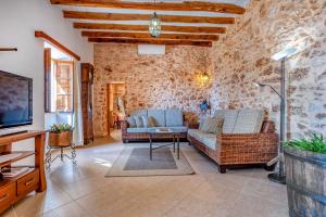a living room with two couches and a tv at Na Corma Nova by dracmallorca in Calonge